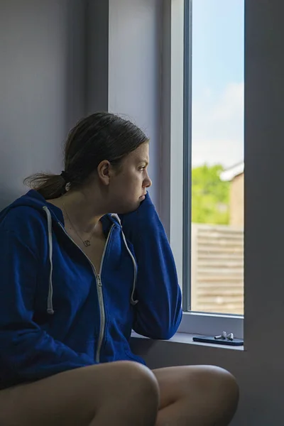 Aufnahme Eines Gelangweilten Teenagers Der Aus Dem Fenster Schaut Stockfoto