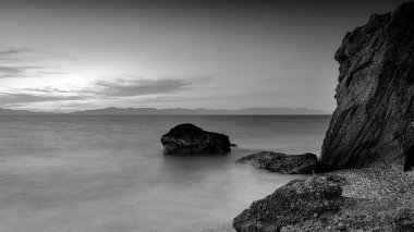 Alacakaranlıkta kayalık Kato Petres Sahili manzarasında uzun pozlama. Rodos, Yunanistan