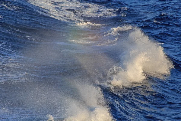 Rainbow above waves in sea — Stock Photo, Image