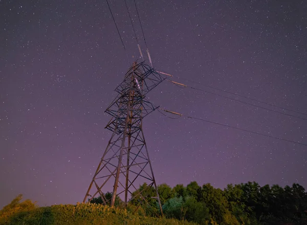 Pilón de electricidad contra el cielo nocturno —  Fotos de Stock