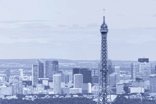 Top part of Eiffel tower against La Defense district — Stock Photo, Image