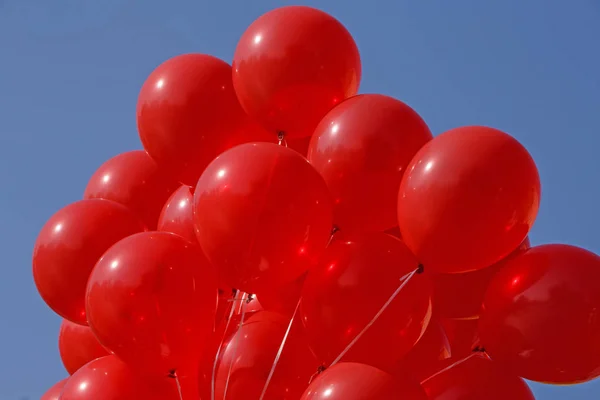 Rode lucht ballonnen tegen blauwe hemel — Stockfoto