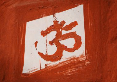 Om sign painted on wall of Hindu  temple in India clipart