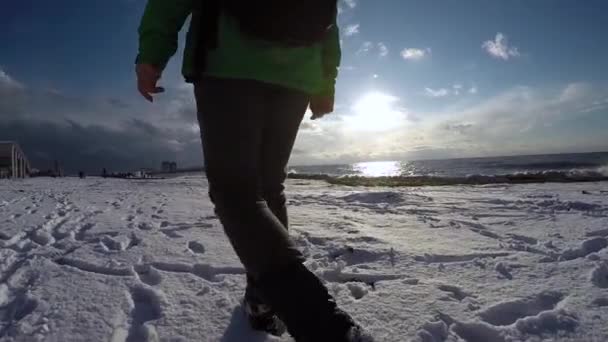 Pasos en la nieve a lo largo del mar en mo lento — Vídeo de stock