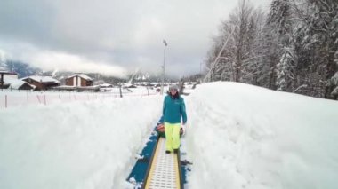 Arkadaşlar kayak merkezinde iyi eğlenceler. Yetişkinler kar borularını sever. Arkadaş grubu dağdaki dev bir kar tepesinden aşağı tüp kazıyor.