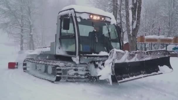 Síközpontok szórakoztatására. Snow Grooming Machine a síközpontban. Hóápoló gép elhajtja elhagyja az utat a sima kordbársony hó síelők Krasnaya Polyana — Stock videók