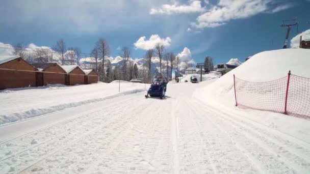 Друзья веселятся на лыжном курорте. Молодые улыбающиеся люди едут на снегоходах. Три человека на снегоходе наслаждаются зимним днем . — стоковое видео