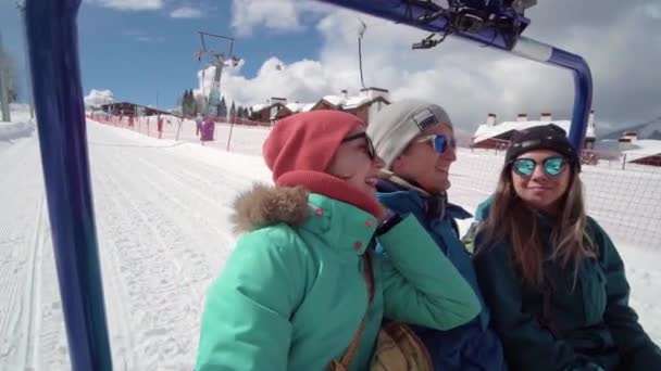 Vänner ha kul på skidorten. Unga leende människor som åker snöskoter. Tre personer på skoter njuter av vinterdagen. — Stockvideo