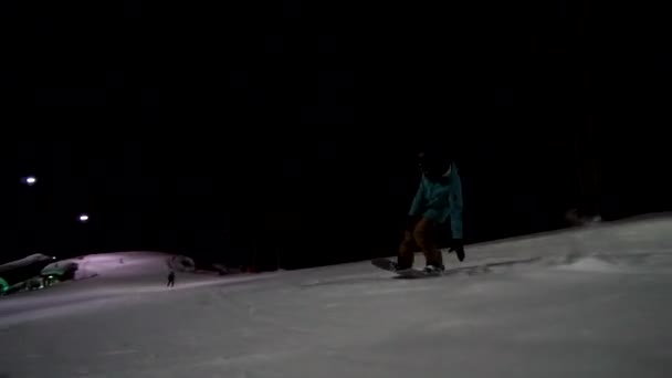 Поездка на сноуборде под ночным небом. Верховая езда ночью на лыжном курорте . — стоковое видео