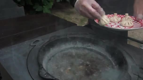 Cuisine traditionnelle caucasienne. Cuisine traditionnelle géorgienne, khinkali. Eau bouillante dans le grand pot en acier dans la cuisine extérieure . — Video