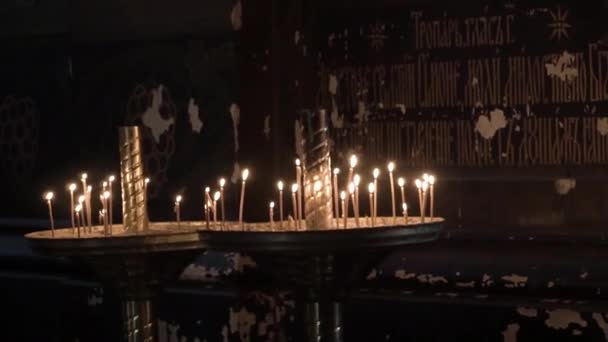 Ortodox keresztény templom. Gyertyák égnek a sötétben. — Stock videók