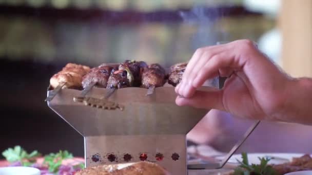 Grillmeister dreht das Fleisch auf dem Grill. kleiner tragbarer Herd, traditionelle Serviergerichte — Stockvideo