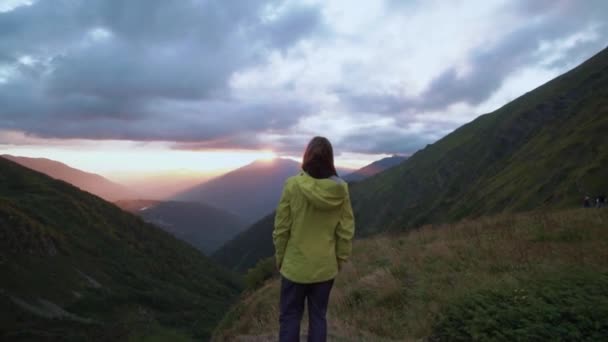 A girl enjoys the view from the mountain during sunset. the girls head in the foreground — Stock Video