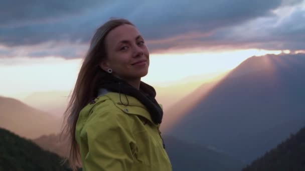 A girl enjoys the view from the mountain during sunset. the girls head in the foreground — Stock Video