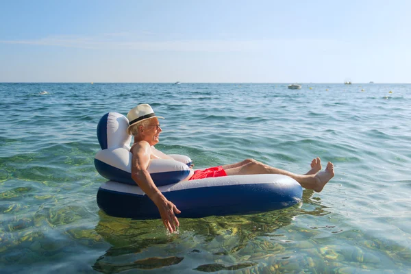 Senior man floating in sea — Stock Photo, Image