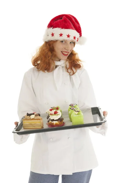 Fêmea padeiro chef com chapéu de Papai Noel com pastelaria de Natal — Fotografia de Stock