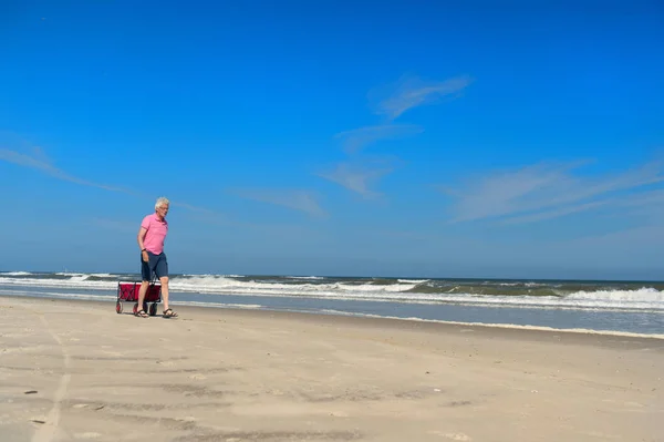 Ανώτερος άνθρωπος περπατώντας με καλάθι στην παραλία — Φωτογραφία Αρχείου