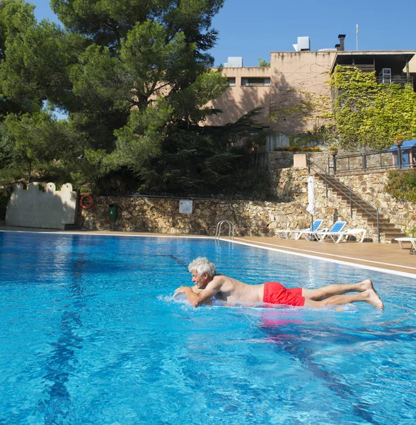 Senior man floating on water — Stock Photo, Image