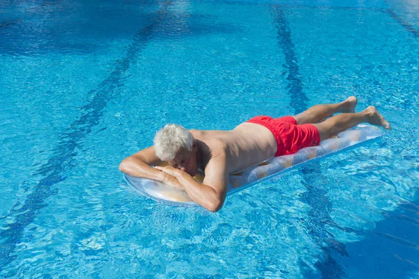 Uomo anziano galleggiante sull'acqua — Foto Stock