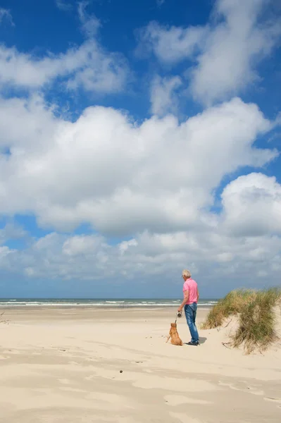 Homme avec chien à la plage — Photo