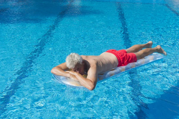 Hombre mayor flotando en el agua — Foto de Stock