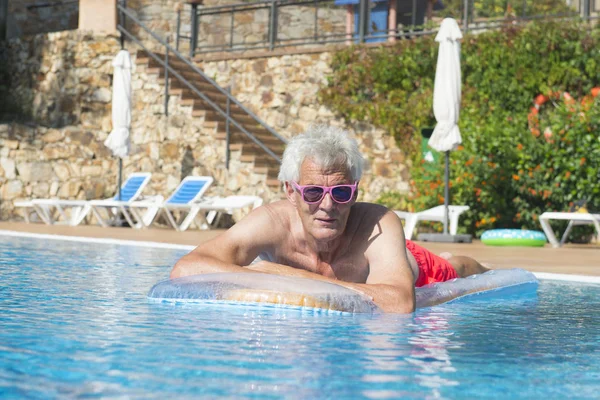 Uomo anziano galleggiante sull'acqua — Foto Stock