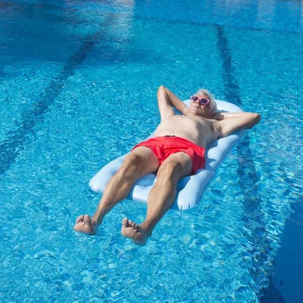 Senior man floating on water — Stock Photo, Image