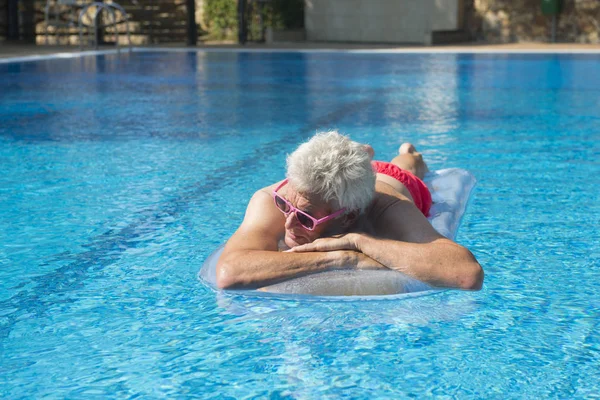 Starší muž, plovoucí na vodě — Stock fotografie