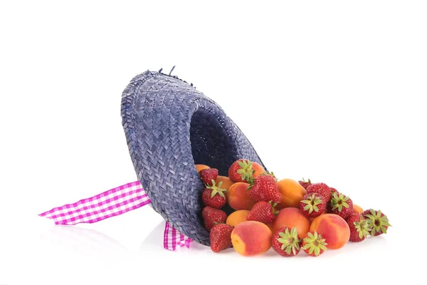Summer straw hat with abricots and strawberries — Stock Photo, Image