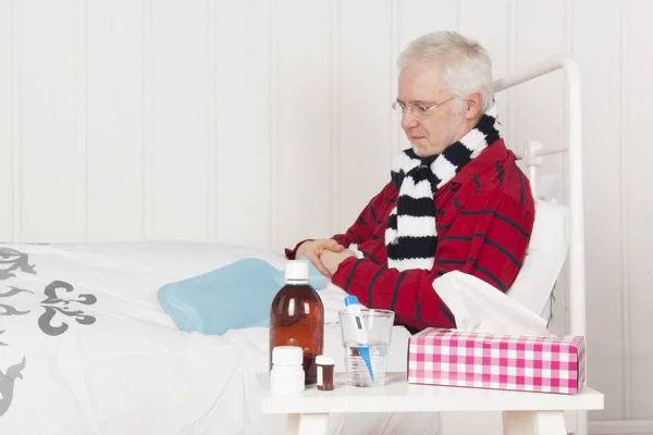 Sjuk man sittande i sängen — Stockfoto