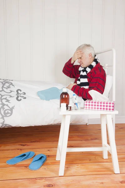 Sick man sitting in bed — Stock Photo, Image