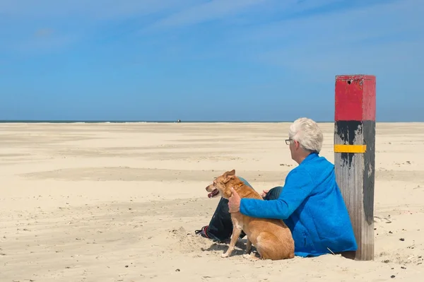 Man med hund på stranden — Stockfoto