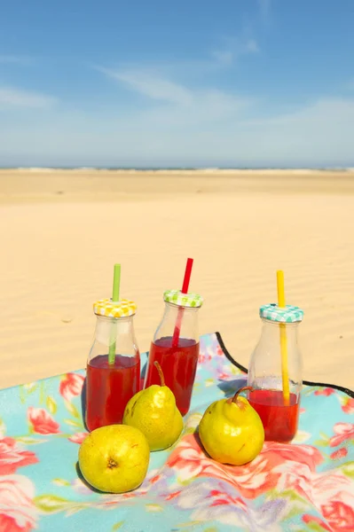 瓶柠檬水和水果在海滩 — 图库照片