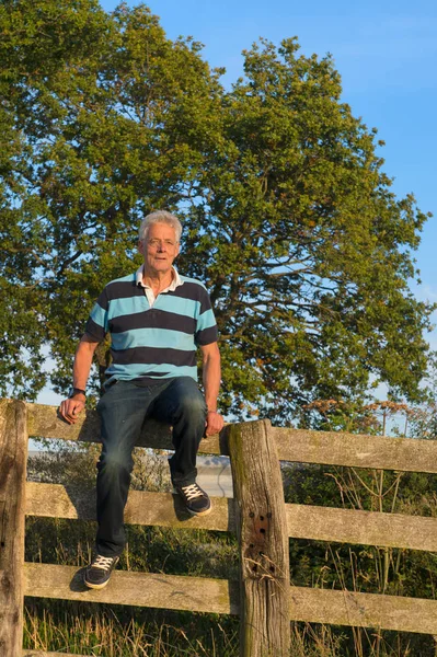 Senior man on fence — Stock Photo, Image