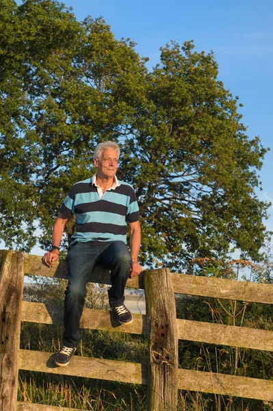 Senior man on fence — Stock Photo, Image