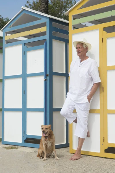 カラフルなビーチ小屋と犬と年配の男性 — ストック写真