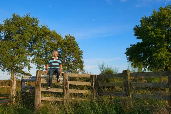 Senior man op hek — Stockfoto