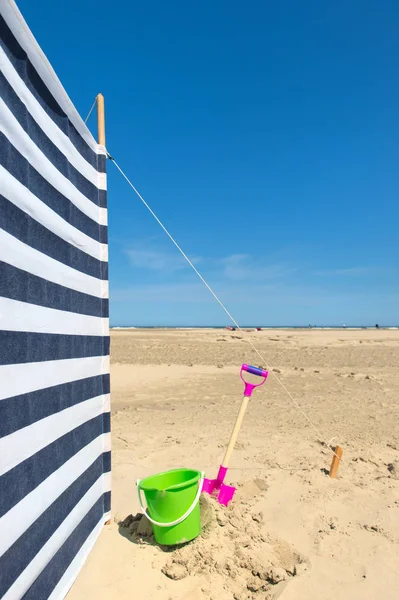 Gestreepte abrivent op het strand — Stockfoto