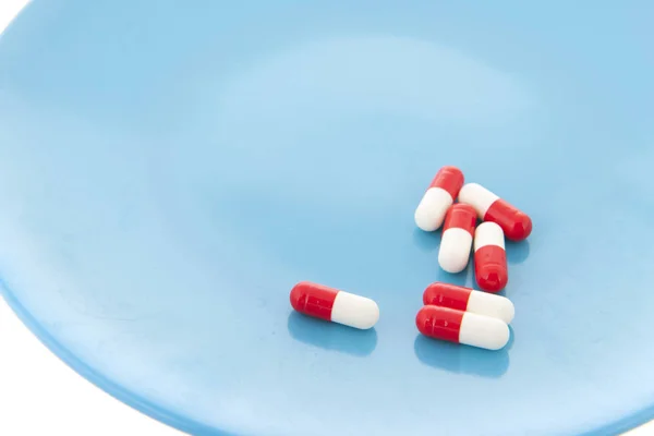 Capsules in red and white on plate — Stock Photo, Image