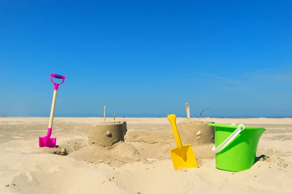 Castelo de areia com brinquedos na praia — Fotografia de Stock