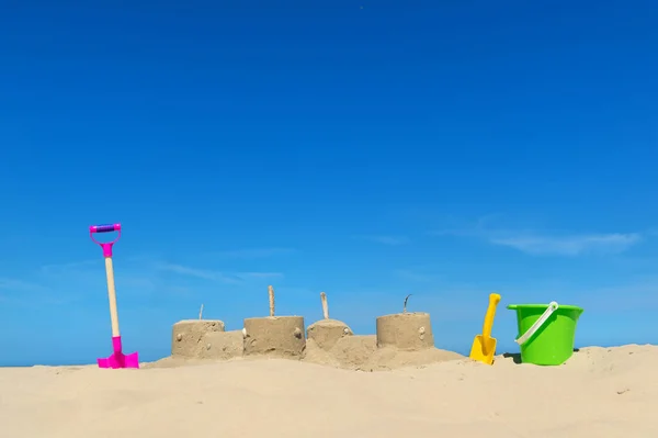 Zandkasteel met speelgoed op het strand — Stockfoto