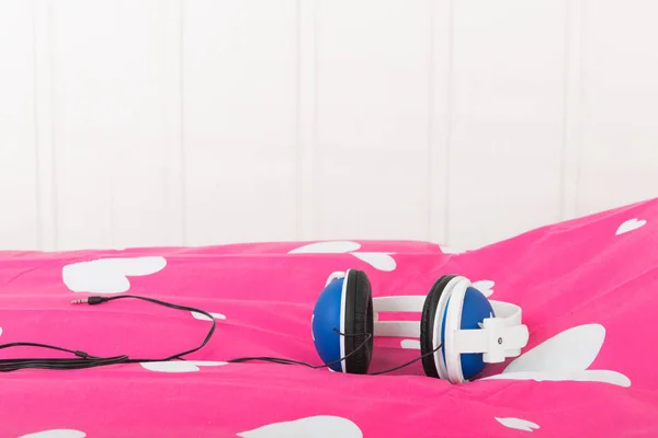 Kopfhörer Auf Rosa Bett — Stockfoto