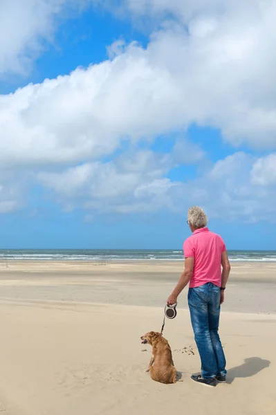 Homme avec chien à la plage — Photo