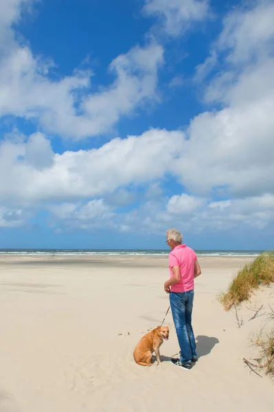 Uomo con cane in spiaggia — Foto Stock