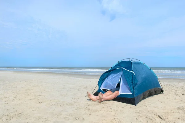 Человек кемпинг в убежище на пляже — стоковое фото