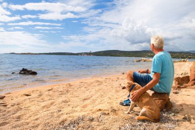 Man with dog at the coast from Corsica with Genoese tower clipart