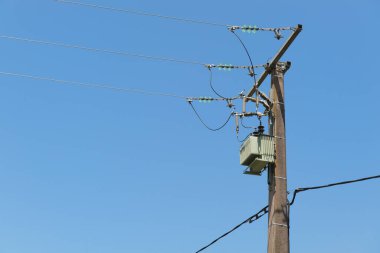 Elektrik direği ve iplikler mavi gökyüzüne karşı