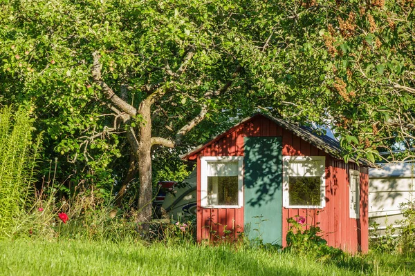 Červený dřevěný dům v zahradě v Švédsko — Stock fotografie