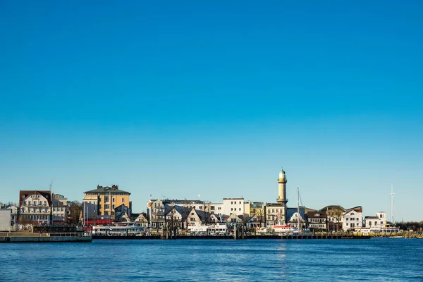 Edifícios, farol e céu azul em Warnemuende — Fotografia de Stock