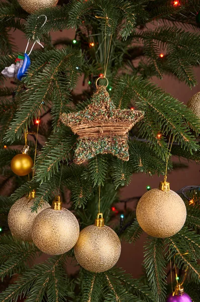 Bolbos de ouro e estrela na árvore de Natal close-up — Fotografia de Stock